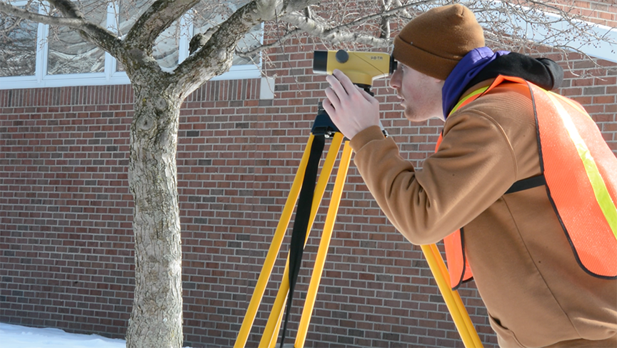 Civil engineering student using surveying equipment