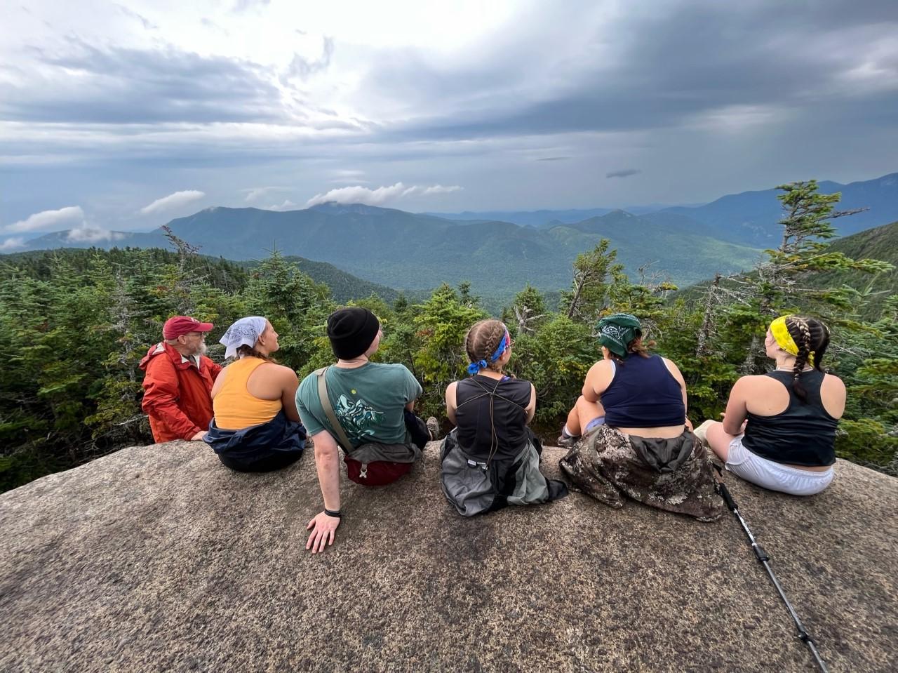 学生们在野外旅行，坐在巨石上