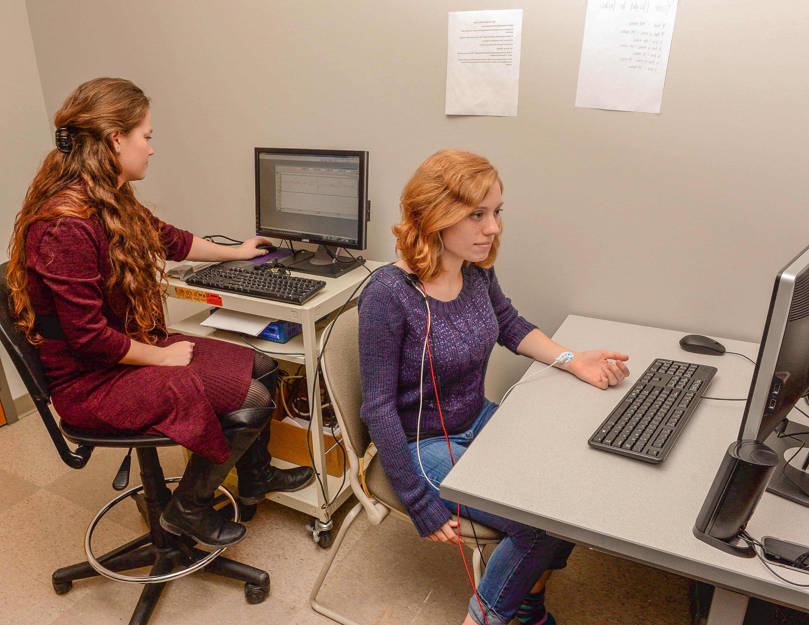 两个女学生坐在教室里摆弄电脑